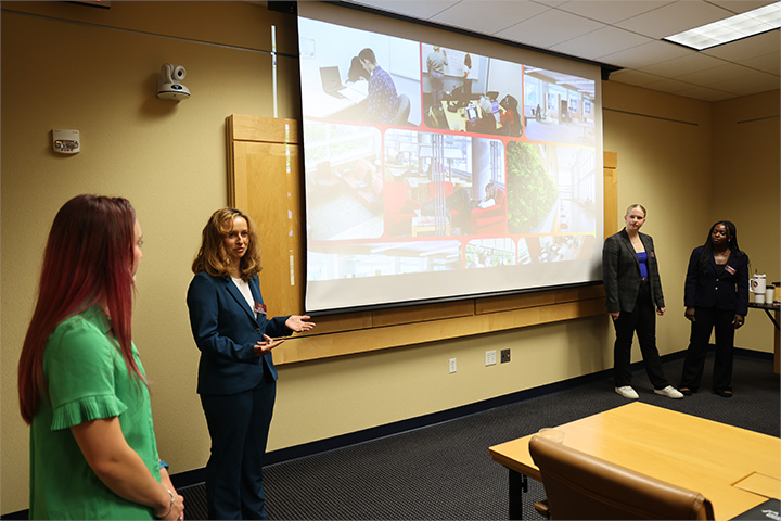 A group of students presenting in the library.