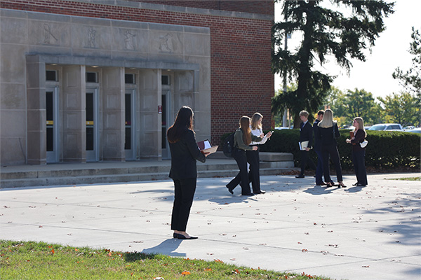 A group of people walking outside Finch Fieldhouse