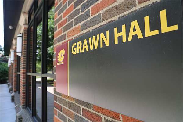 Grawn Hall's entrance sign is prominent int the foreground of this picture of the mall side entrance to Grawn.
