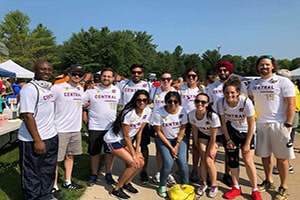 A group of students wearing white Central Michigan University shirts stand together and smile at the 2018 Walk for Hope.