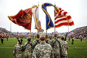 The Reserve Officers' Training Corps carrying flags onto a football field at a Central Michigan University game.