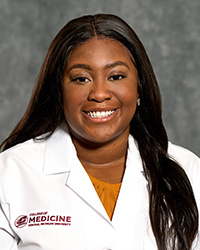 Heather Anderson, a College of Medine medical student smiling for a professional headshot while wearing a white coat.