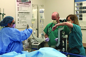 Medical residents in scrubs work together in surgery.