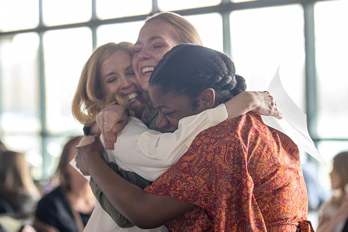 Three female medical students hug, smiling with a small tear, as they celebrate where they Matched for their medical school residencies..