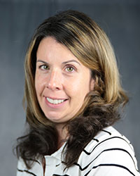 a woman with brown hair and a white shirt