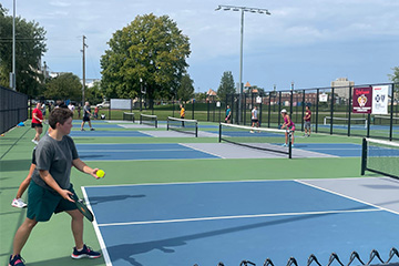 Player serves at Pulse3 Hearts and Paddles Pickleball Tournament.