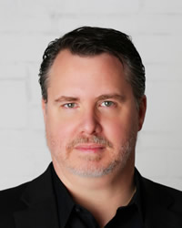 Headshot of Andy Bazakis wearing a black shirt.