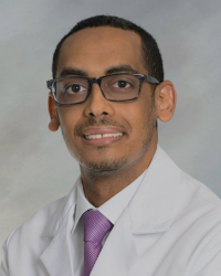 a man in a white coat and purple tie
