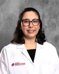 Acosta, Grace_student_200x250 A woman with shoulder-length dark hair and glasses is wearing a white lab coat with