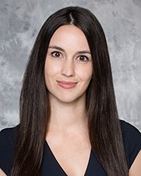 A professional headshot of Mindy Prows in dark attire against a gray background.