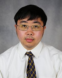 A student in a white collared shirt and tie smiles for a headshot.