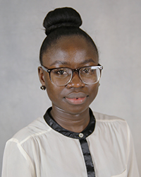 A professional headshot of Oluwayemisi Oyeleke in light attire against a gray background.