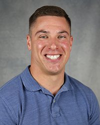 A professional headshot of Matthew Petruso in light blue attire against a gray background.