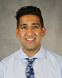 A professional headshot of Rajvinder Singh in light blue attire against a gray background.