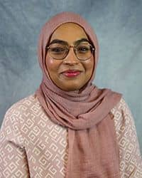 Headshot of Farina Kanwal wearing a pink outfit with white patterns.