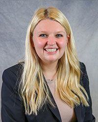 Headshot of Brittany Ladson wearing a gray blazer over a light brown top.