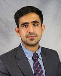 Headshot of Hamza Malik wearing a gray suit.