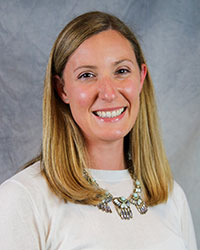 Headshot of Elizabeth Fearey wearing a white top and large necklace.