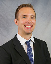 Headshot of Ryan Woldahl wearing a black suit.