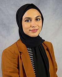 Headshot of Nancy Saleh wearing a brown blazer with a black colored hajib covering around her head and neck.