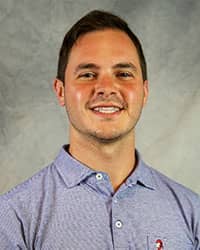 Headshot of Aaron Schneider wearing a blue polo shirt.