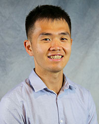 Headshot of Larry Wang wearing a blue dress shirt.