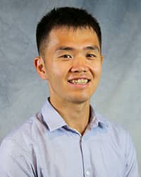 Headshot of Larry Wang wearing a blue dress shirt.