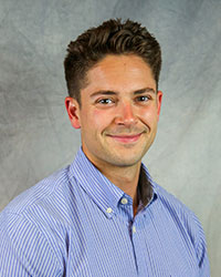 Headshot of Charles Keane wearing a blue shirt.