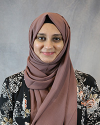 Headshot with Sayera Muqarram wearing a black print top.