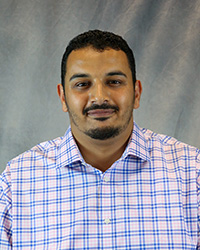 Headshot of Abdulsalam Salem wearing a print button-up shirt.