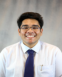 Headshot of Sachin Singh wearing a white shirt and a blue tie.