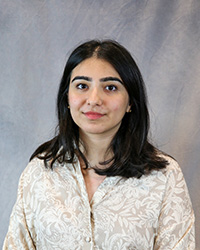 Headshot of Yamna Waseem wearing a beige print top.