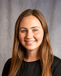 Kosnik, Natalie Natalie Kosnik is wearing a black blouse and has long brown hair.