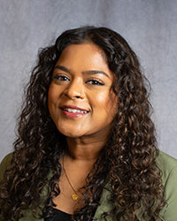 Shaylene Velu is wearing a green blazer with a black top.