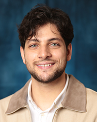 Al-Khatib, Basel a man smiling for a picture, in a beige jacket