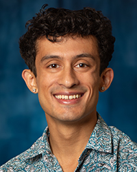 a man smiling at the camera, with a print top