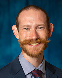 a man with a mustache smiling