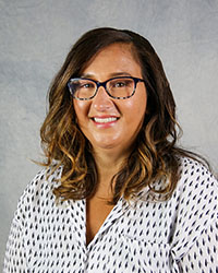 a woman wearing glasses and a white shirt