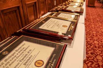 Framed gesidency graduation diplomas laying on a white table.