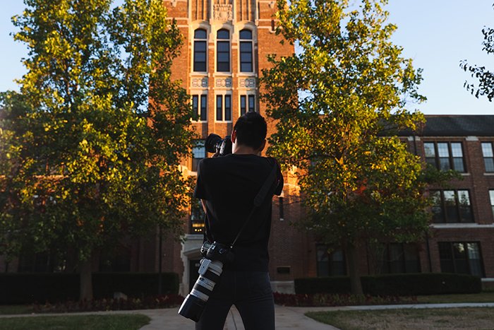 Photojournalism student taking a photo of Warriner Hall.
