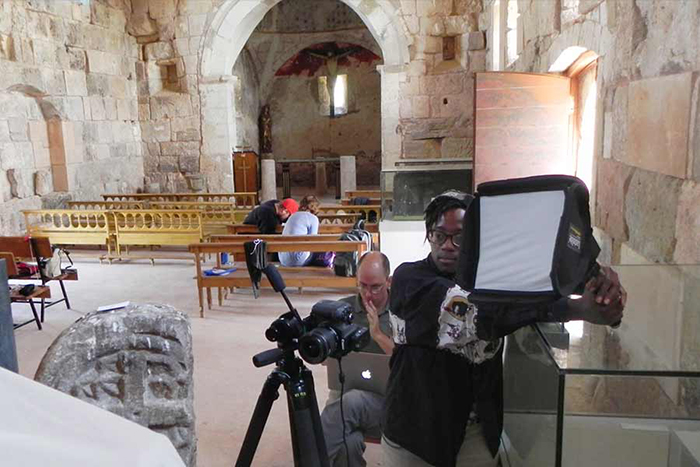 Student set up lighting equipment to take an interior photo of a church in Florence, Italy.