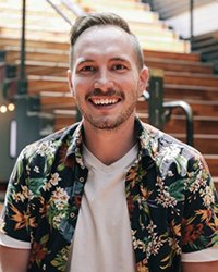 Headshot of Dan Hilvka in front of a staircase.