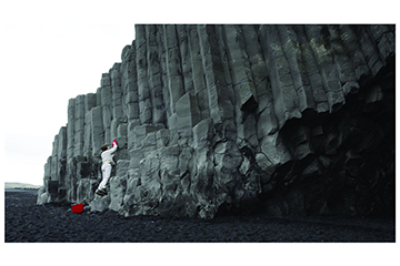 20250115_Events_Searing_003_360x240 Judy Natal: video still from The Custodian. Person washing the side of a cliff with a bucket and a wash cloth.