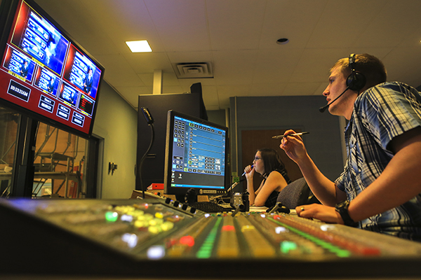 Students working at the CMU tv station on newscasting equipment.
