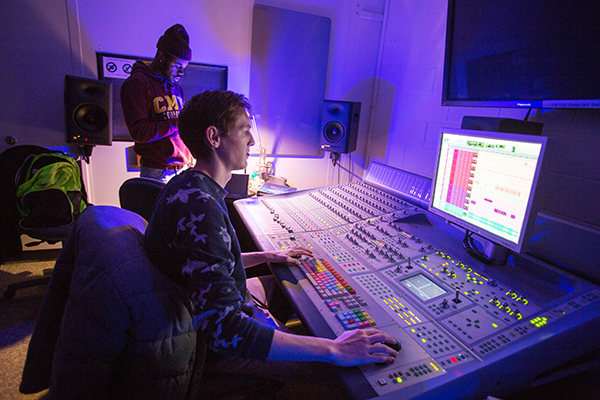 Students working on a sound board a CBA recording studio