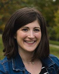 Headshot of Lauren Laur wearing jean jacket with trees in the background.