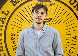 Headshot of Blace Carpenter standing in front of the CMU Seal