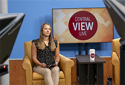 Central View Live news anchor Ella Pierzecki sitting in her chair in front of the cameras for a taping of an episode