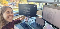 Communications student Fiona Ambrose sitting at her computer while writing a paper