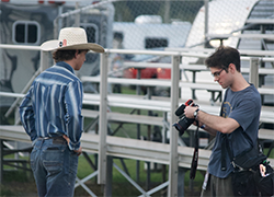 Photojournalism student Mark Hoover taking photos at a local rodeo